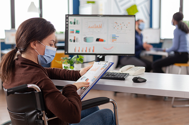 Woman reviewing charts while seated at her desk.