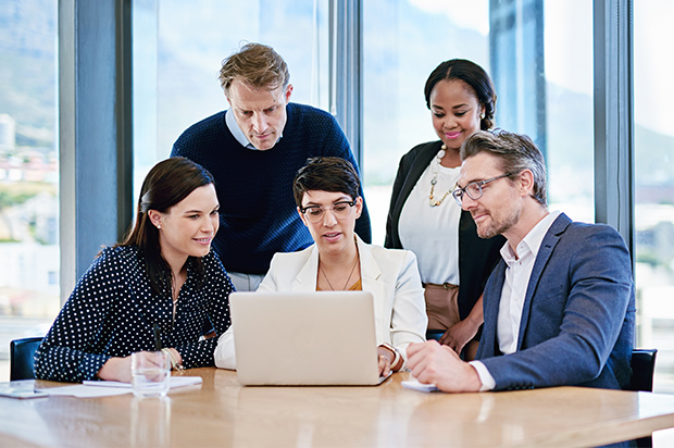Business team collaborating on a project using a laptop.