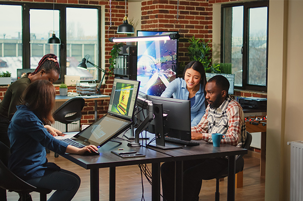 Team working on digital design projects in creative office.